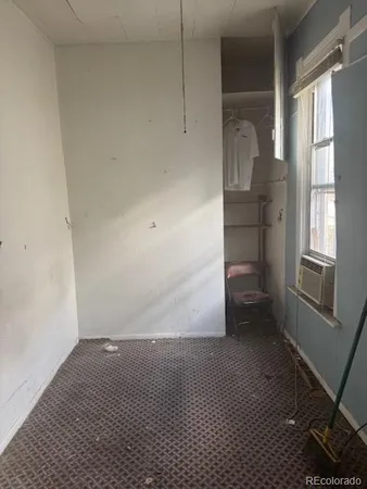 a view of empty room with windows and wardrobe