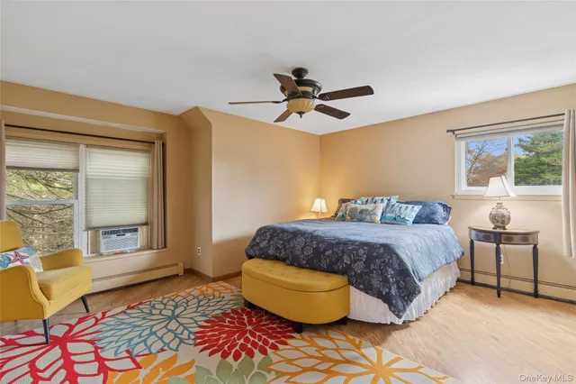 a spacious bedroom with a bed a window and potted plant