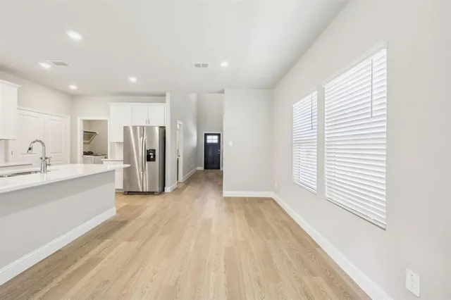 a view of a kitchen with refrigerator and windows