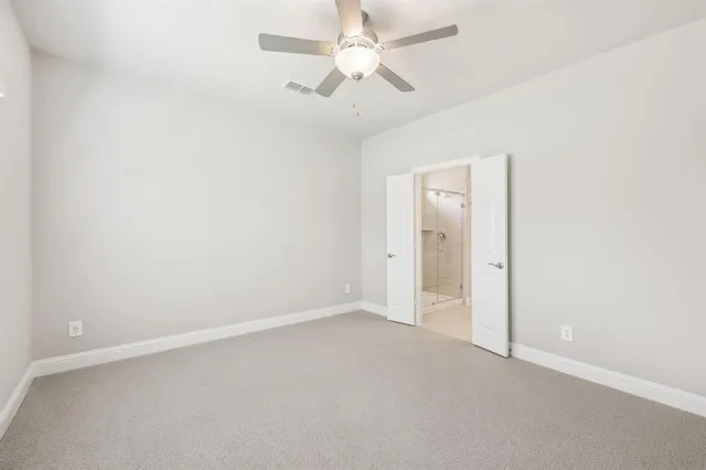 an empty room with a ceiling fan and a fan