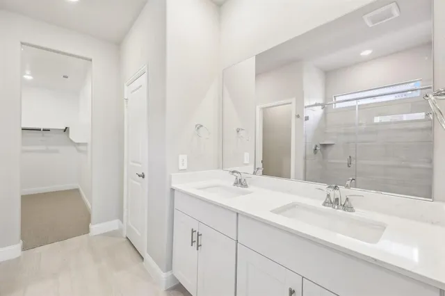 a bathroom with a double vanity sink mirror double and shower