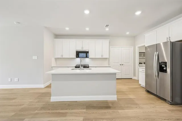 a view of kitchen with stainless steel appliances granite countertop a sink stove and refrigerator