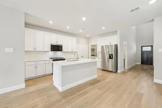 a kitchen with refrigerator cabinets and wooden floor