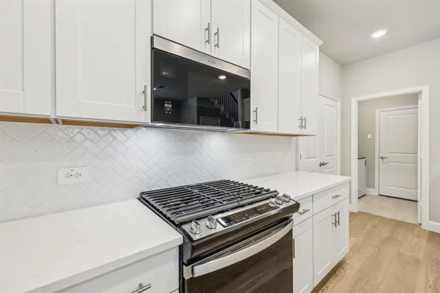 a kitchen with a stove and white cabinets