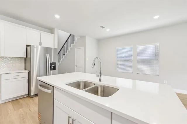 a kitchen with a refrigerator sink and cabinets