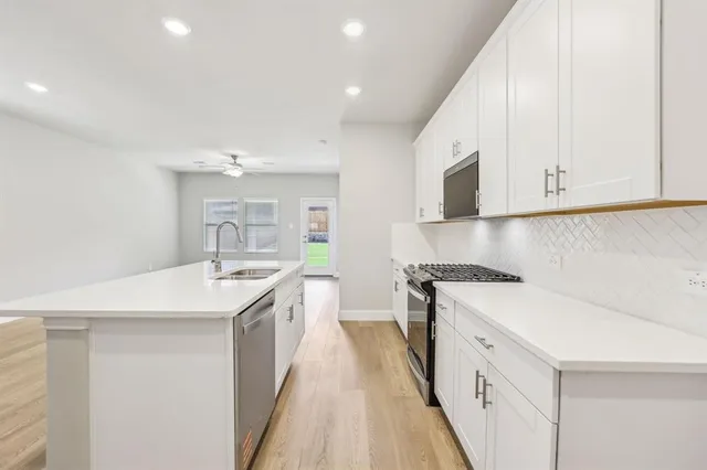 a kitchen with a sink stove and cabinets