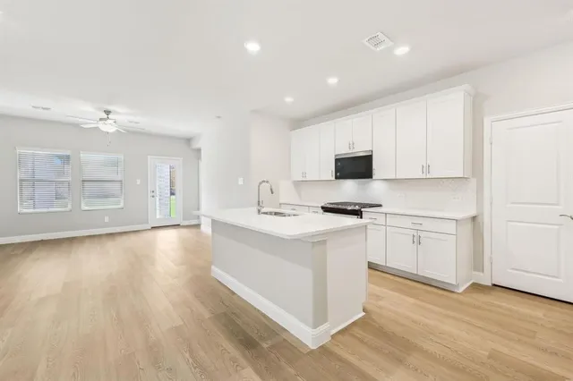 a kitchen with a sink cabinets and wooden floor