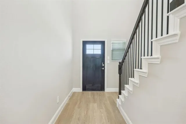 an entryway of a house with wooden floor and stairs