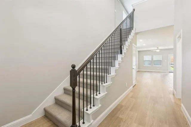 a view of staircase with wooden floor and white walls