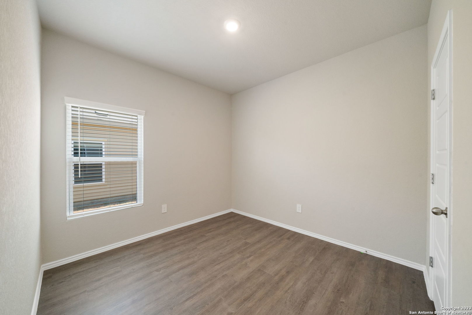 10107 Abrams View Converse, TX 78109 - Photo 19 of 25 a view of an empty room with wooden floor and a window