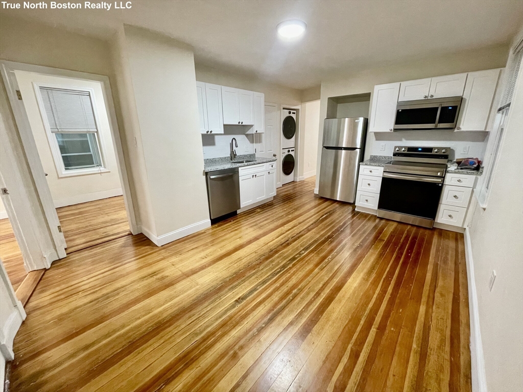 a kitchen with stainless steel appliances a stove top oven a sink and a refrigerator