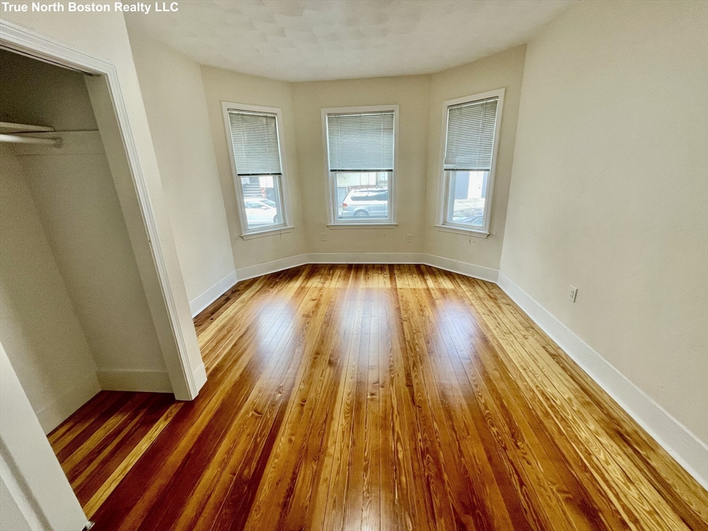 207 Princeton Street, Unit 1 Boston, MA 02128 - Photo 10 of 15 a view of a room with wooden floor and staircase