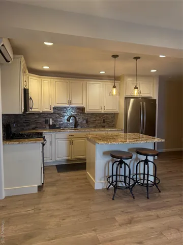 a kitchen with stainless steel appliances granite countertop a stove a sink dishwasher and a refrigerator