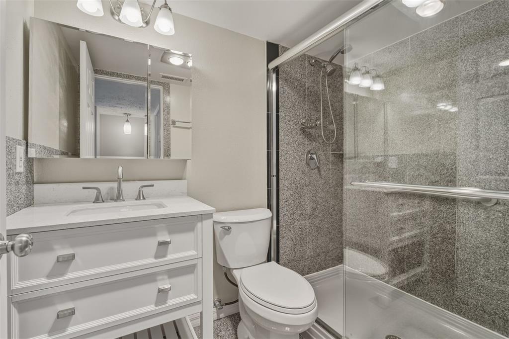 5055 North Beach Road, Unit 106 Englewood, FL 34223 - Photo 22 of 34 a bathroom with a sink a toilet and shower