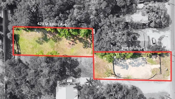 an aerial view of a house with a yard and large trees