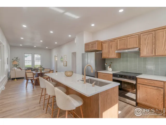 a kitchen with a dining table chairs and white appliances