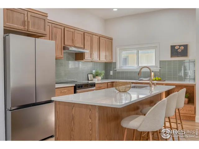 a kitchen with stainless steel appliances granite countertop a sink a refrigerator and a granite counter tops