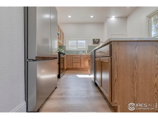 a kitchen with kitchen island wooden cabinets and refrigerator