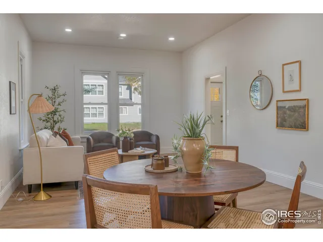 a living room with furniture a window and a potted plant