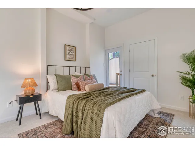 a bedroom with a bed a lamp and a potted plant