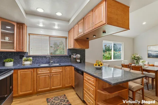 a kitchen with stainless steel appliances granite countertop a sink a stove counter space and cabinets