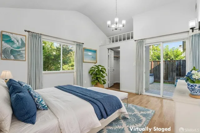 an empty room with a chandelier fan and wooden floor
