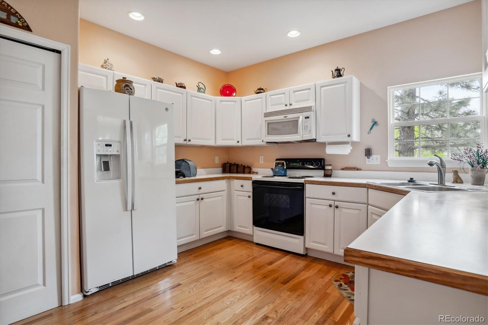 6322 Trailhead Road Highlands Ranch, CO 80130 - Photo 10 of 32 a kitchen with granite countertop a refrigerator stove top oven and sink