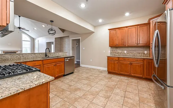 a kitchen with stainless steel appliances granite countertop a stove a sink and a refrigerator