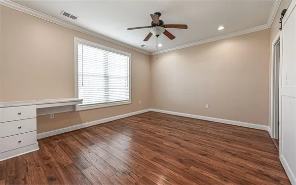a view of an empty room with a window and wooden floor