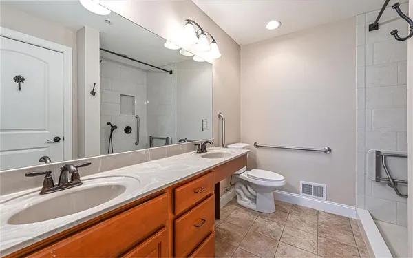 a bathroom with a double vanity sink mirror and toilet