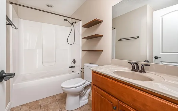 a bathroom with a granite countertop sink a toilet and shower