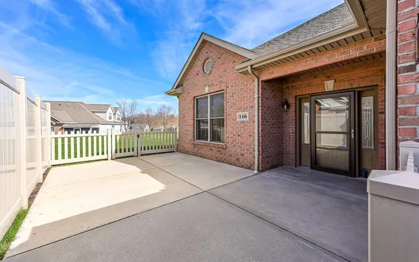 a view of a house with a small yard and wooden fence