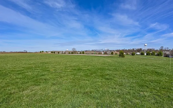 a view of a field with an ocean in background