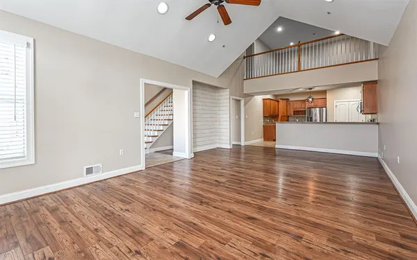 an empty room with wooden floor and windows