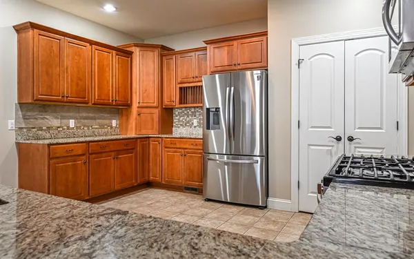 a kitchen with stainless steel appliances granite countertop a refrigerator and a sink