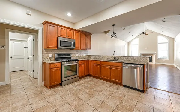 a kitchen with stainless steel appliances granite countertop a stove a sink and a microwave