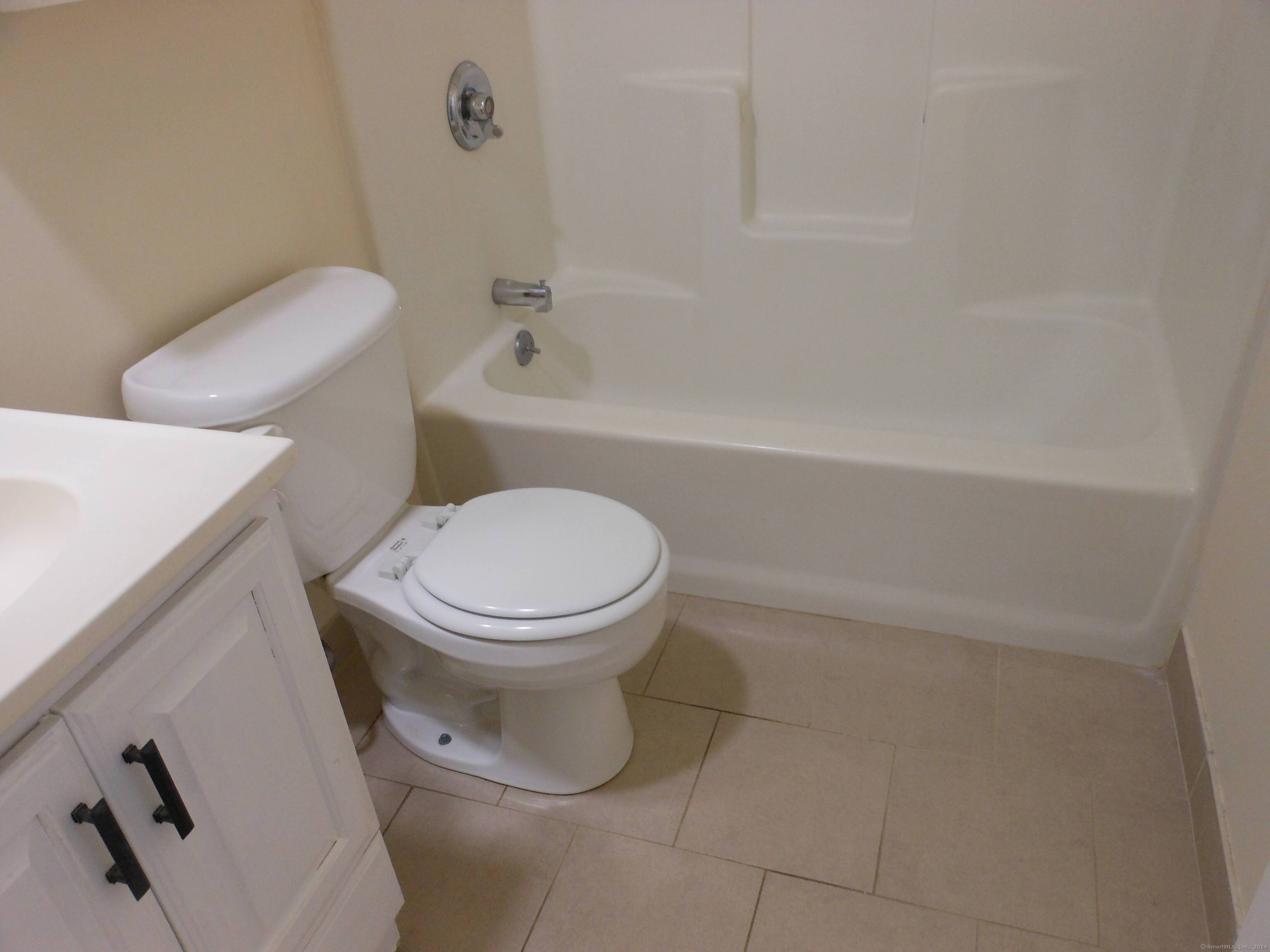 155 Short Beach Road, Unit 206 Stratford, CT 06615 - Photo 17 of 31 a white toilet sitting next to a bath tub