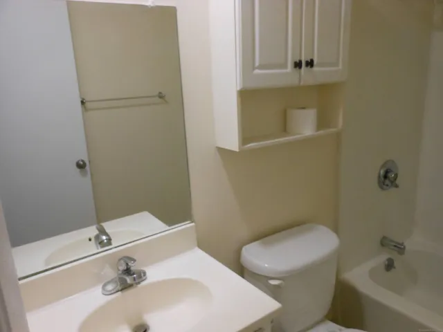 a white toilet sitting next to a bathroom sink