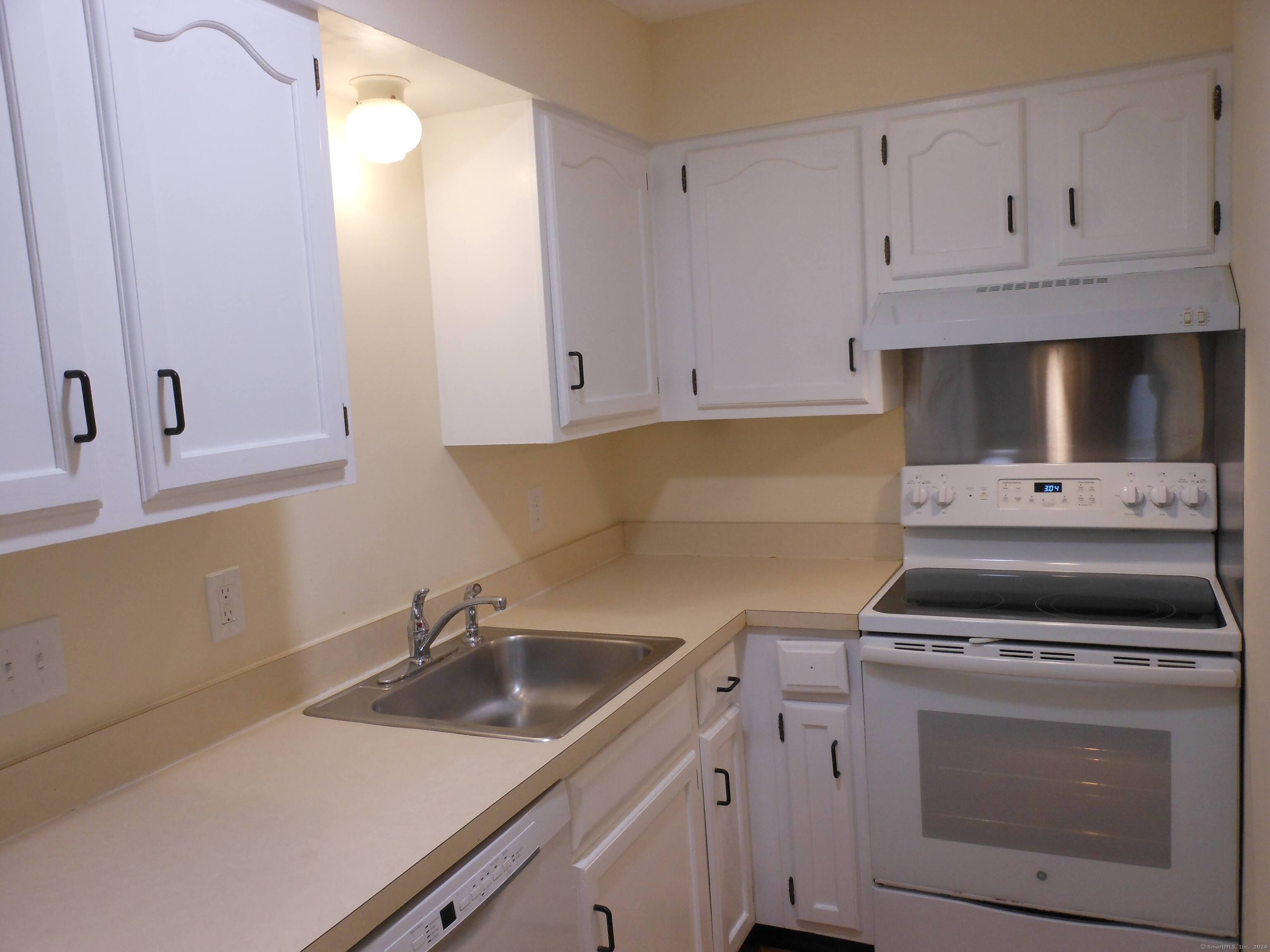 155 Short Beach Road, Unit 206 Stratford, CT 06615 - Photo 6 of 31 a kitchen with white cabinets and appliances