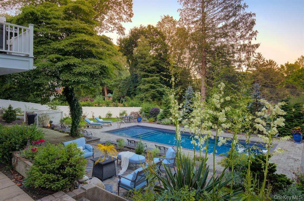 Pool at dusk featuring a patio and an outdoor hangout area