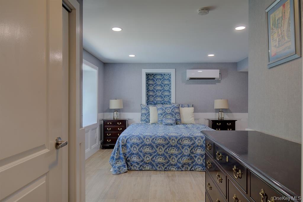 2 Spring Hollow Road Centerport, NY 11721 - Photo 2 of 44 Bedroom with light wood-style flooring, recessed lighting, and a wall unit AC