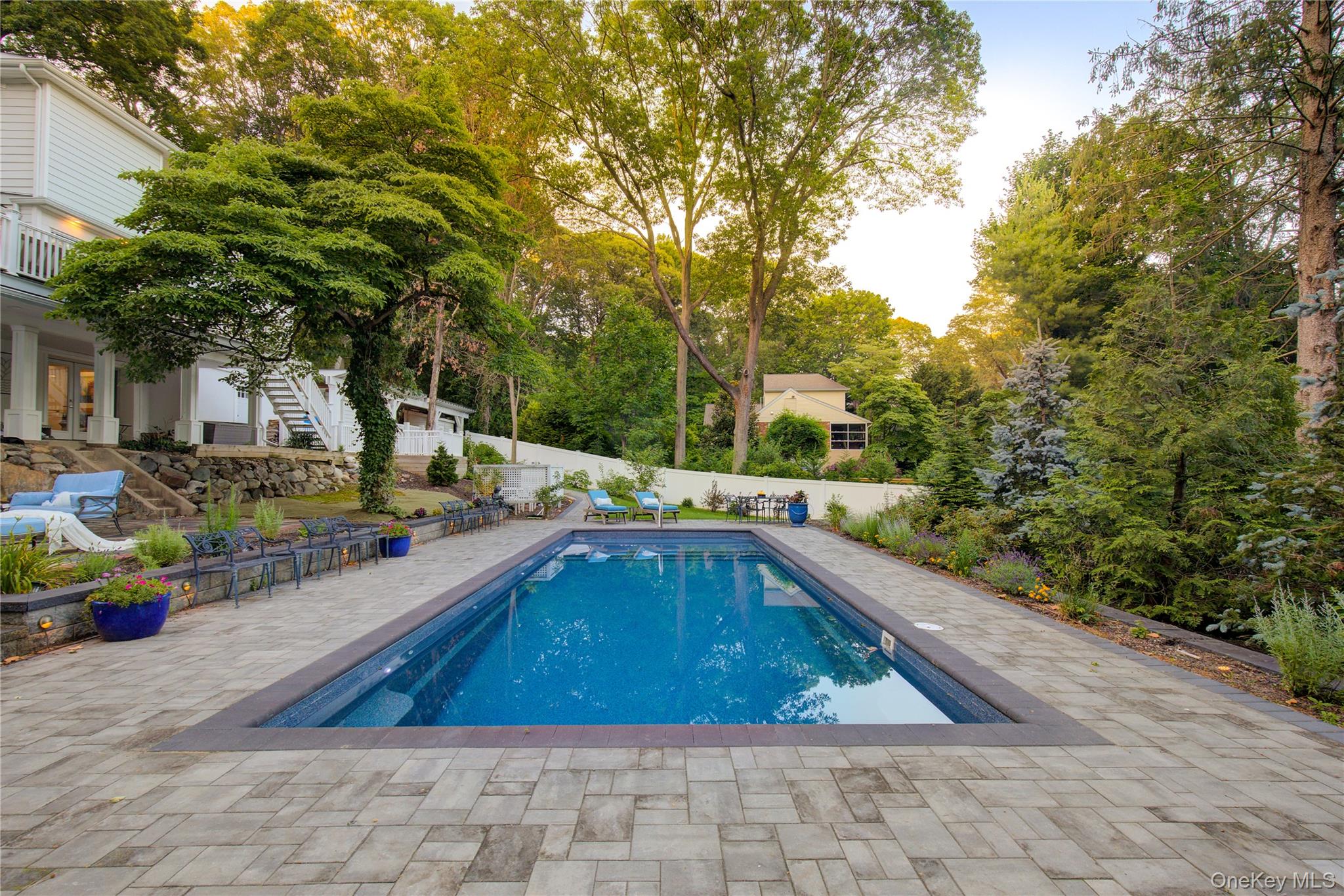 2 Spring Hollow Road Centerport, NY 11721 - Photo 35 of 44 View of swimming pool featuring stairway, a patio area, view of wooded area, and a fenced backyard
