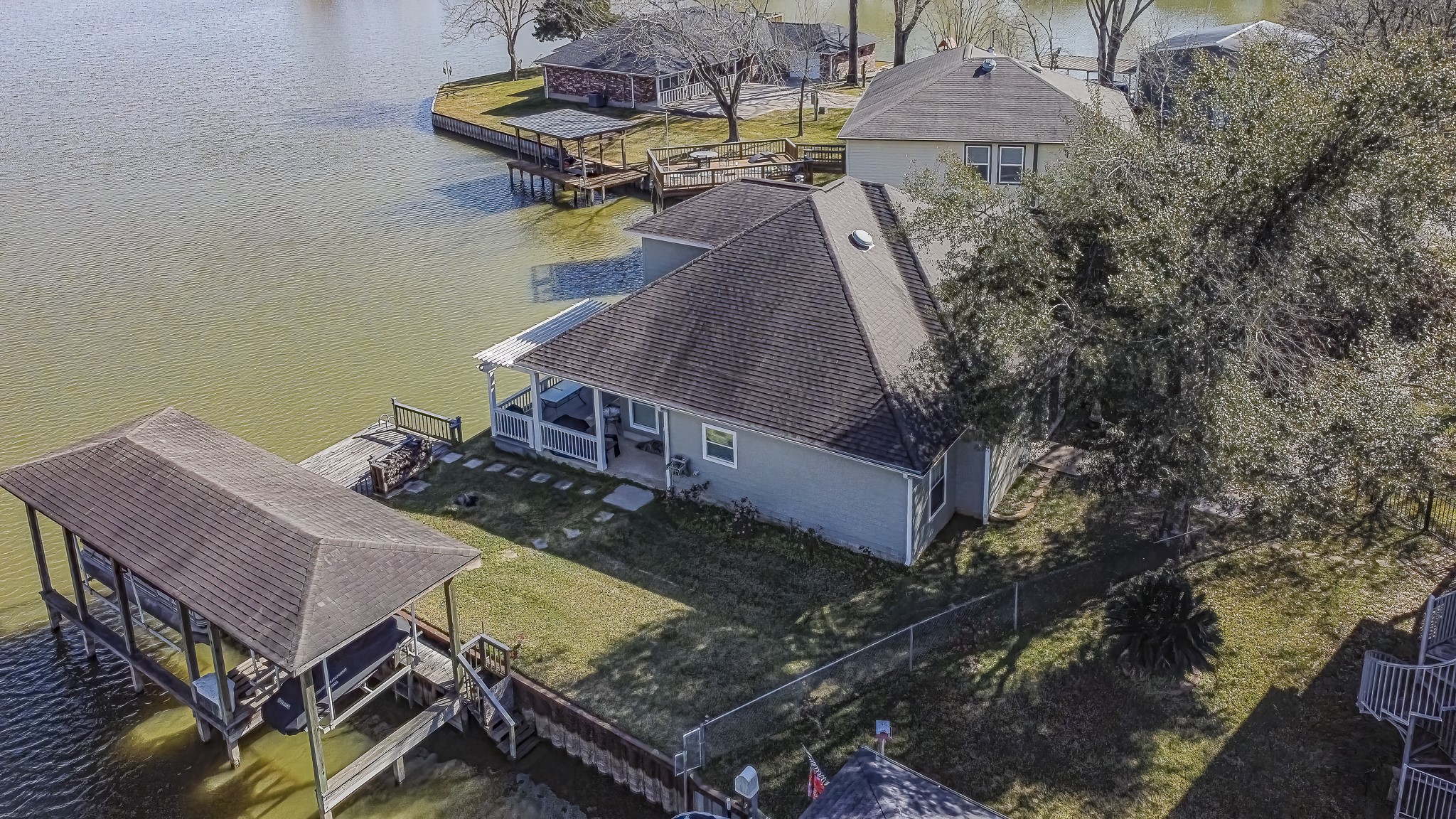 27 Marina Court Coldspring, TX 77331 - Photo 2 of 38 Aerial view showcasing the home’s waterfront setting, spacious deck, and easy access to the lake.