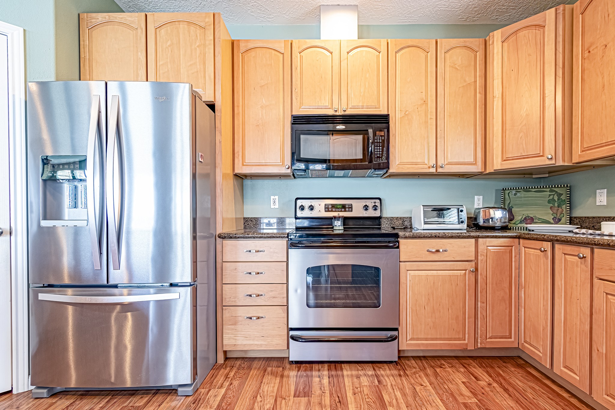 27 Marina Court Coldspring, TX 77331 - Photo 24 of 38 Well-appointed kitchen with stainless appliances, generous storage, and warm wood floors.