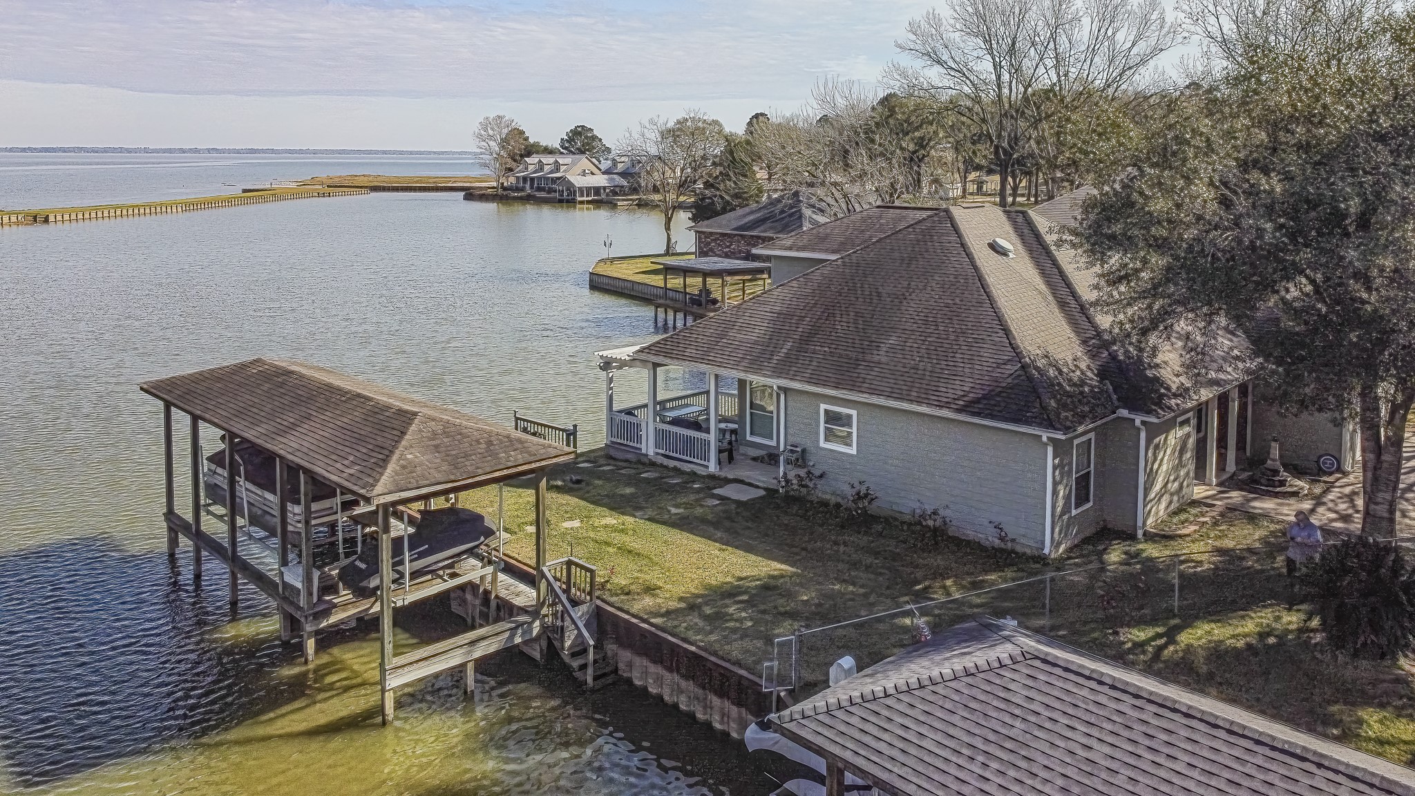 27 Marina Court Coldspring, TX 77331 - Photo 3 of 38 Gently sloping yard leads directly to the dock and boathouse, offering seamless access to the lake.