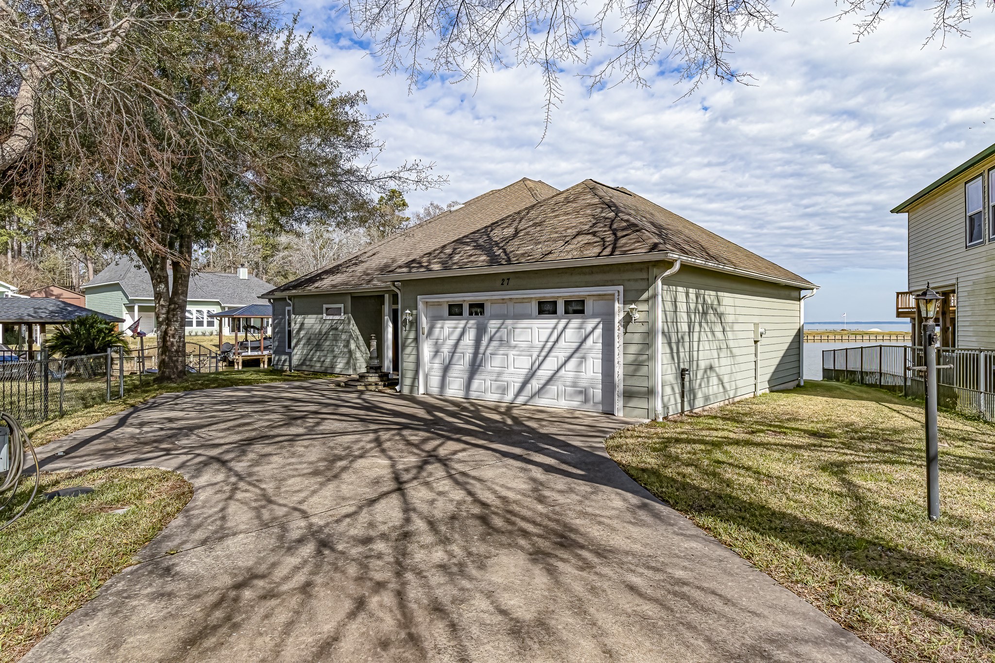 27 Marina Court Coldspring, TX 77331 - Photo 10 of 38 Private driveway with two-car garage and glimpse of the lake beyond.