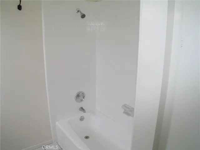 a white bath tub sitting next to a white wooden wall