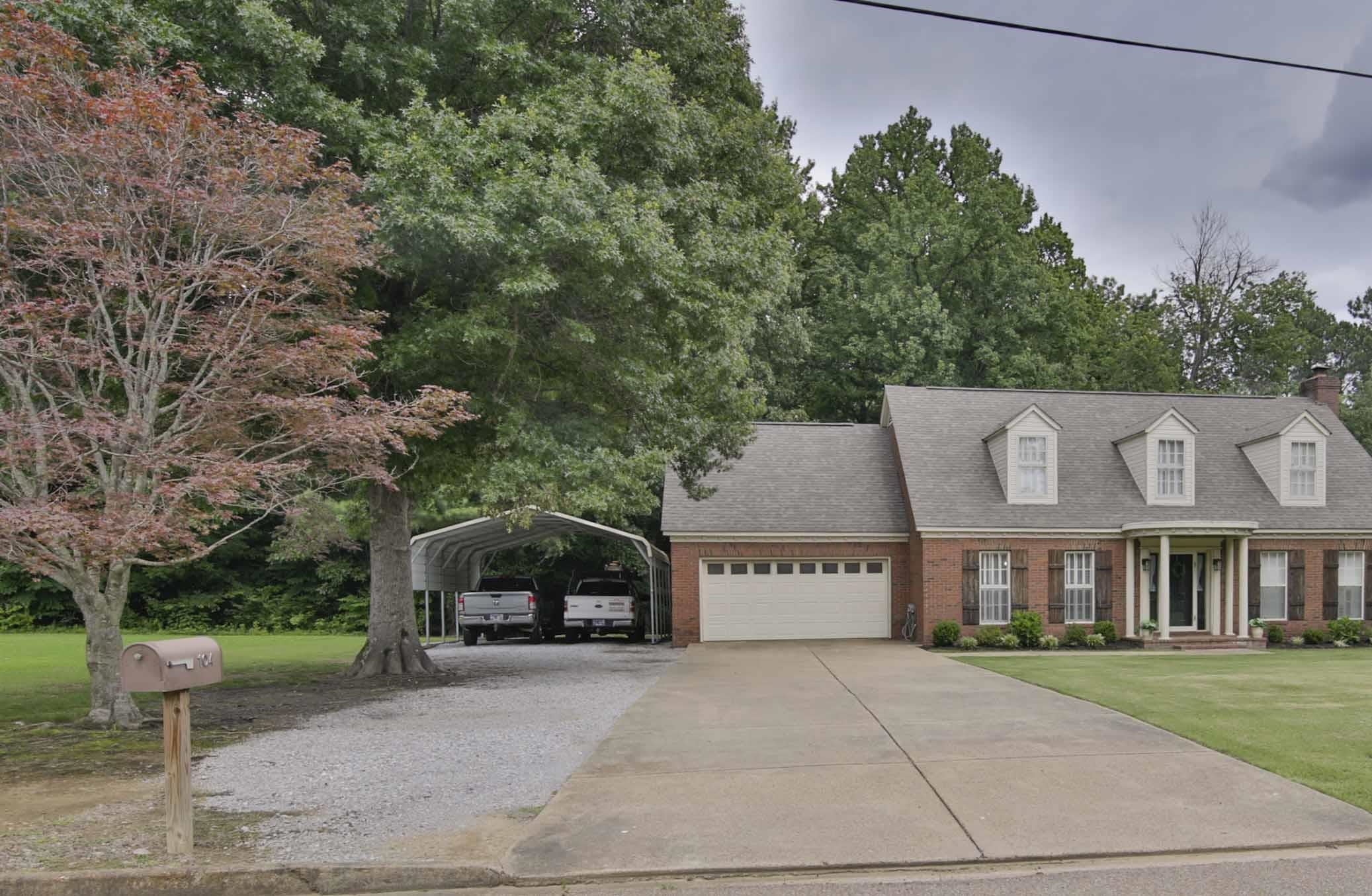 104 Miller Road Covington, TN 38019 - Photo 2 of 25 Brick facade home featuring a prominent front entrance with white columns and dark shutters