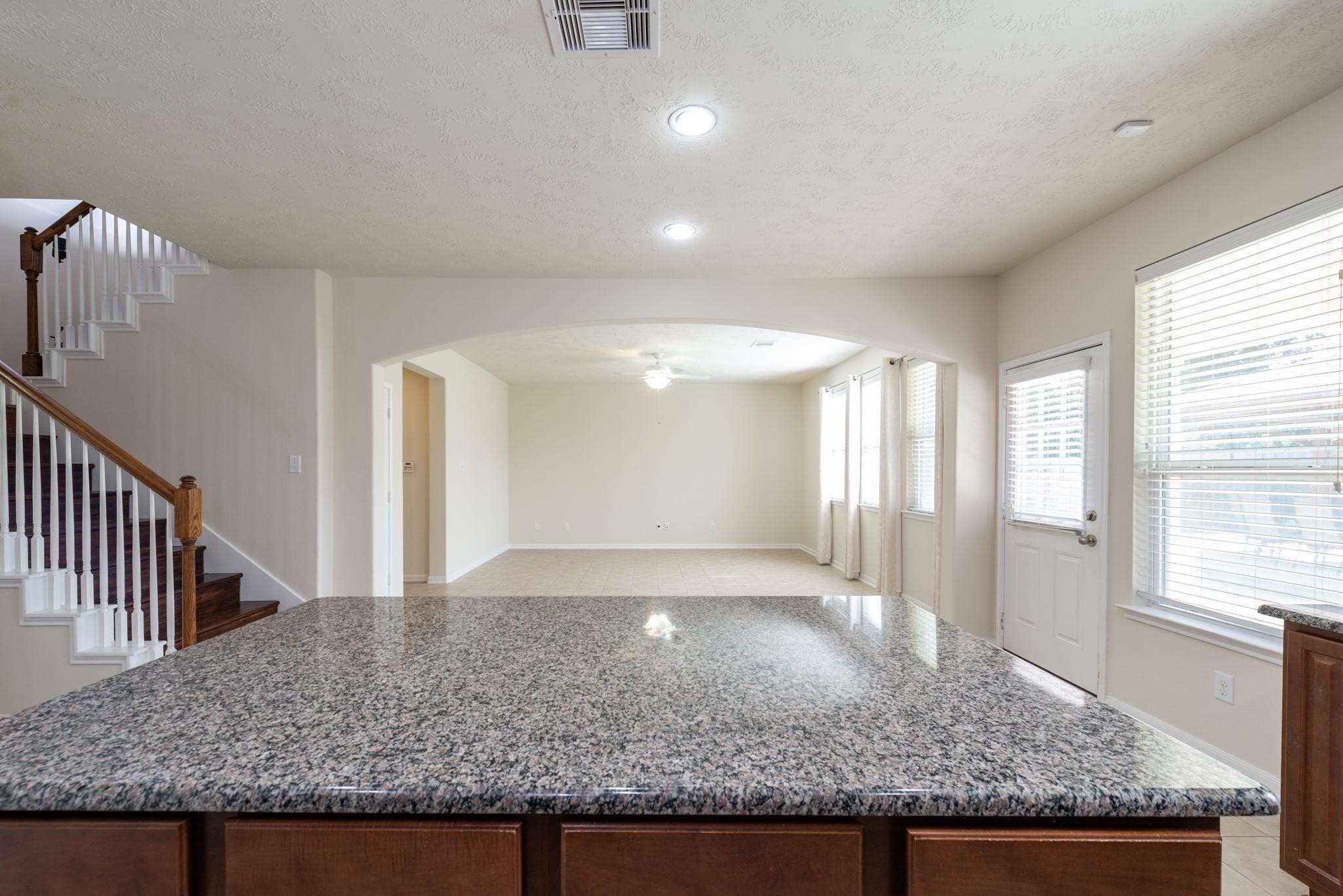 6402 Addlestone Ridge Lane Katy, TX 77494 - Photo 6 of 25 The oversized granite island serves as the heart of the home, offering ample seating, prep space, and a clear view of the family room. The open-concept design seamlessly connects the kitchen, breakfast area, and living space, creating the perfect setting for everyday living and entertaining.