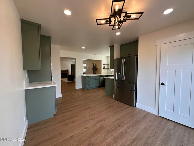 a kitchen with stainless steel appliances kitchen island granite countertop a refrigerator and a stove top oven